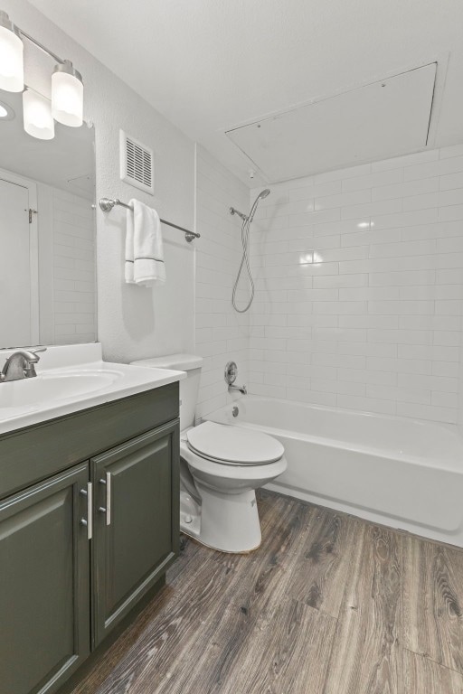 full bath with toilet, wood finished floors, vanity, visible vents, and tub / shower combination