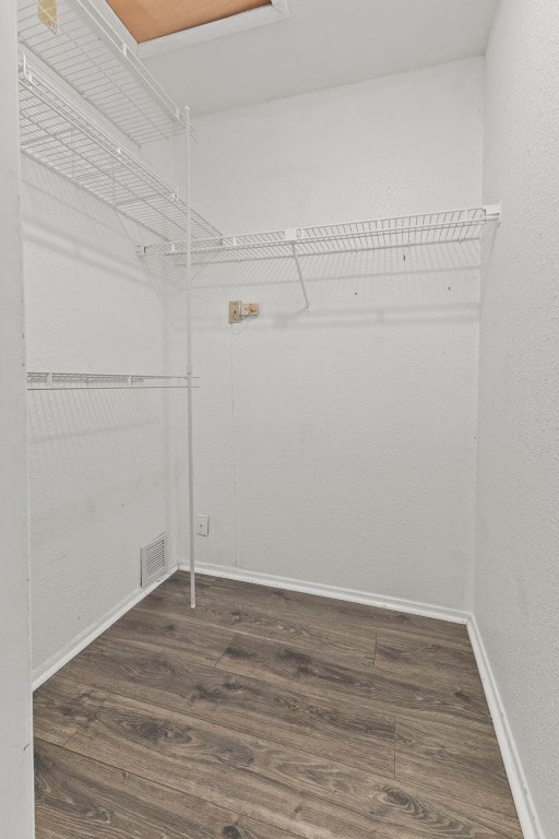 spacious closet featuring dark wood-type flooring and visible vents