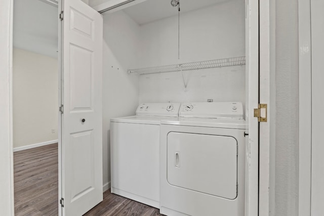 laundry room with laundry area, dark wood-type flooring, washing machine and clothes dryer, and baseboards