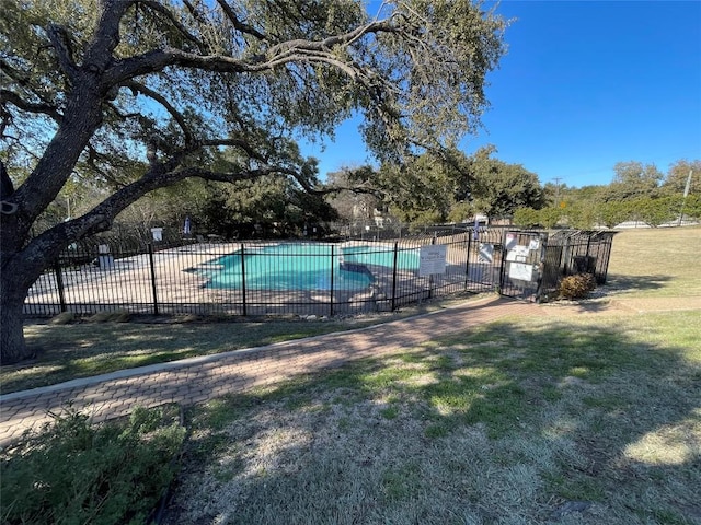 community pool featuring a patio area, fence, and a lawn