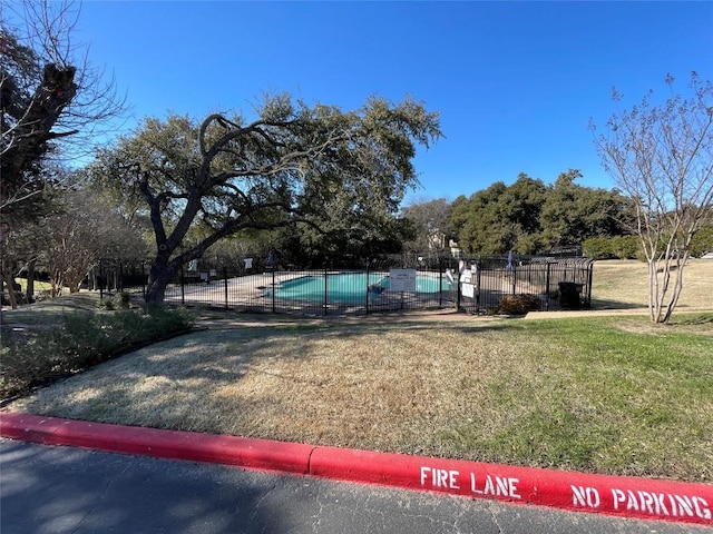 view of pool featuring a yard and fence