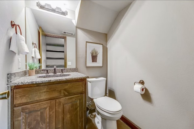 bathroom with baseboards, visible vents, vanity, and toilet