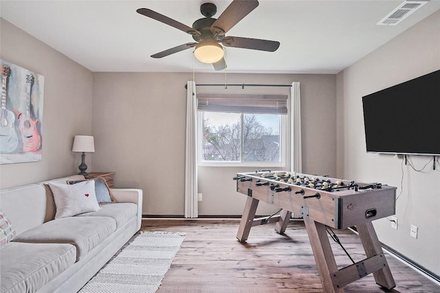 game room featuring light wood-type flooring, baseboards, visible vents, and ceiling fan