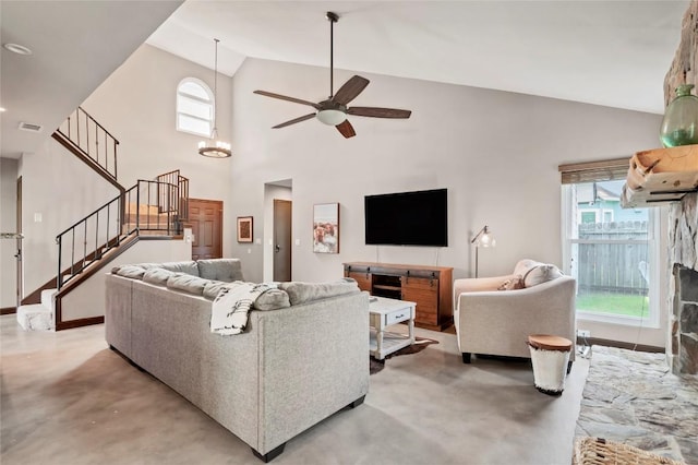 living area with stairs, plenty of natural light, visible vents, and finished concrete floors