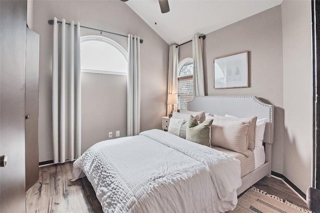 bedroom with a ceiling fan, lofted ceiling, and wood finished floors