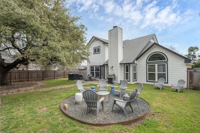 rear view of house with a patio area, an outdoor fire pit, a lawn, and a fenced backyard