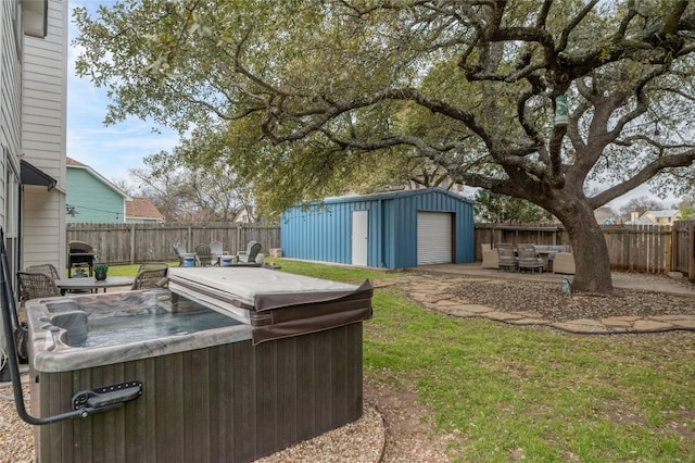 view of yard with a patio area, a hot tub, a fenced backyard, and an outdoor structure