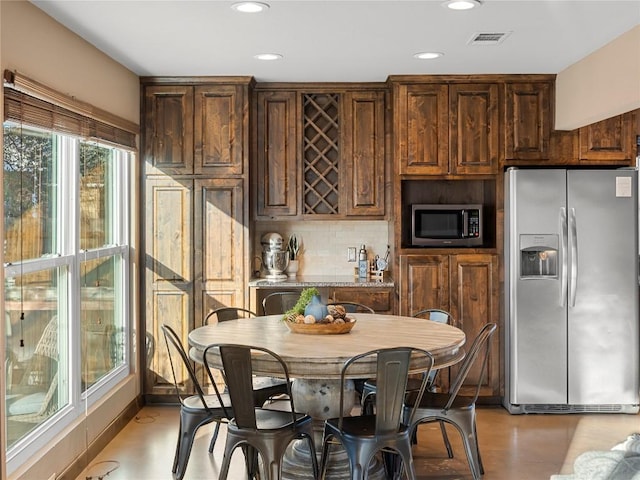 kitchen with tasteful backsplash, appliances with stainless steel finishes, dark brown cabinets, and recessed lighting