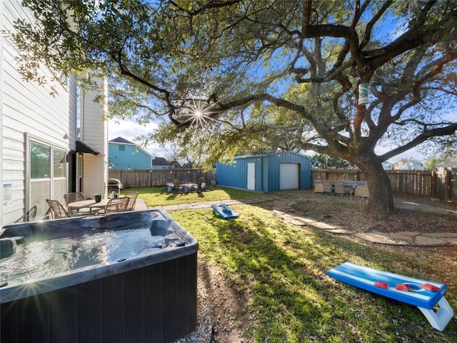 view of yard with an outbuilding, a patio area, a fenced backyard, and a hot tub