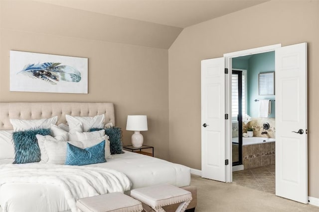 bedroom featuring connected bathroom, light colored carpet, vaulted ceiling, and baseboards