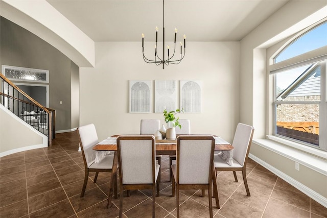 tiled dining space featuring a notable chandelier, baseboards, and stairs