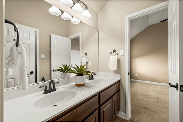 bathroom featuring a sink, baseboards, and double vanity