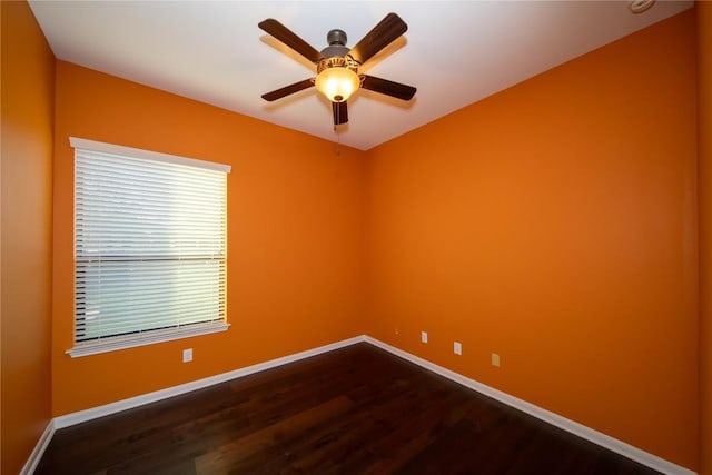 unfurnished room featuring ceiling fan, dark wood-style flooring, and baseboards