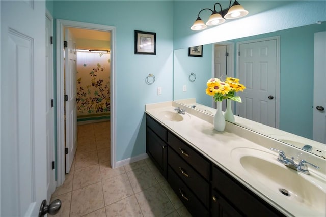 full bathroom with double vanity, a sink, baseboards, and tile patterned floors