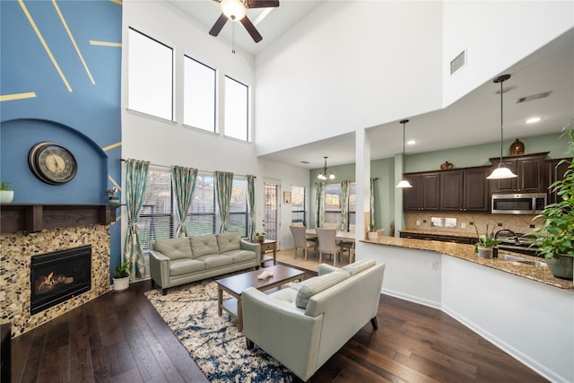 living area with dark wood-style flooring, a fireplace, and visible vents