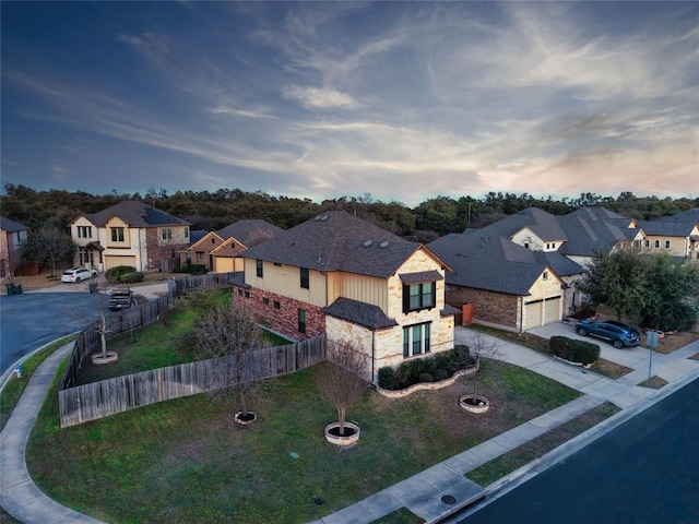 view of front of house featuring concrete driveway, fence, a garage, a residential view, and stone siding