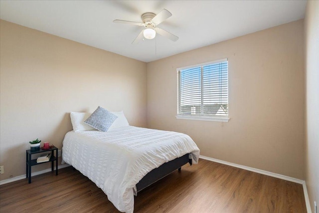 bedroom featuring ceiling fan, wood finished floors, and baseboards