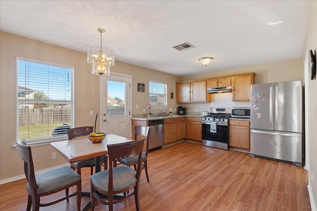 kitchen featuring visible vents, light wood-style flooring, appliances with stainless steel finishes, light countertops, and under cabinet range hood