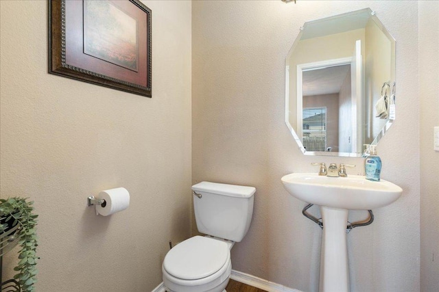 bathroom featuring toilet and baseboards