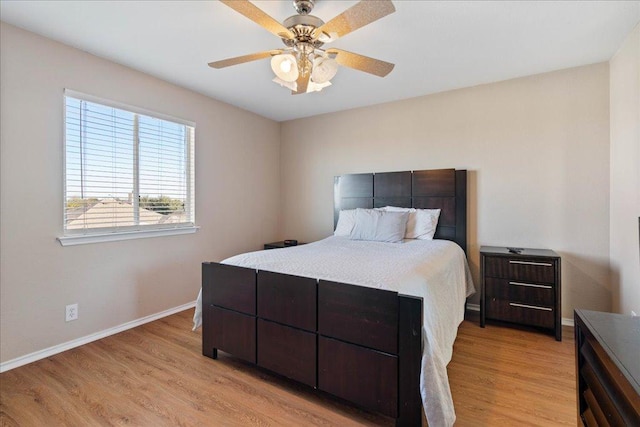 bedroom with light wood-style flooring, baseboards, and ceiling fan