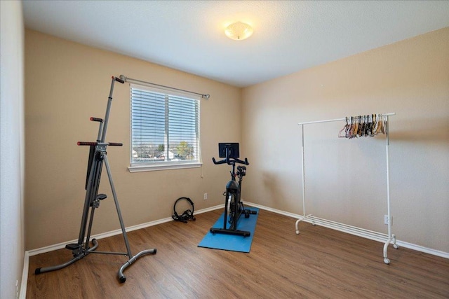 workout area featuring baseboards and wood finished floors