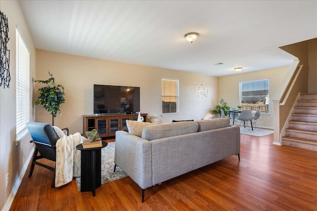 living room featuring stairway, wood finished floors, and baseboards