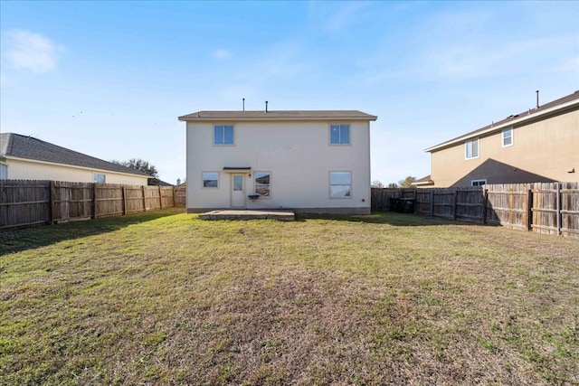 back of property featuring a yard, a patio, and a fenced backyard