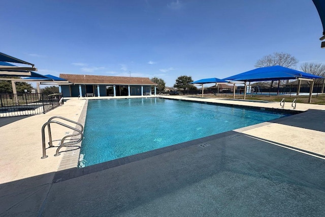 community pool with fence and a patio