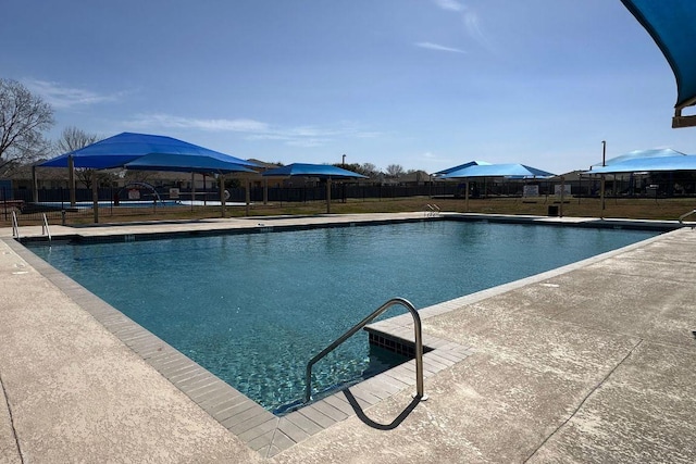 community pool featuring a lawn and fence