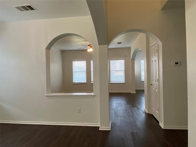 interior space featuring visible vents, ceiling fan, baseboards, and wood finished floors