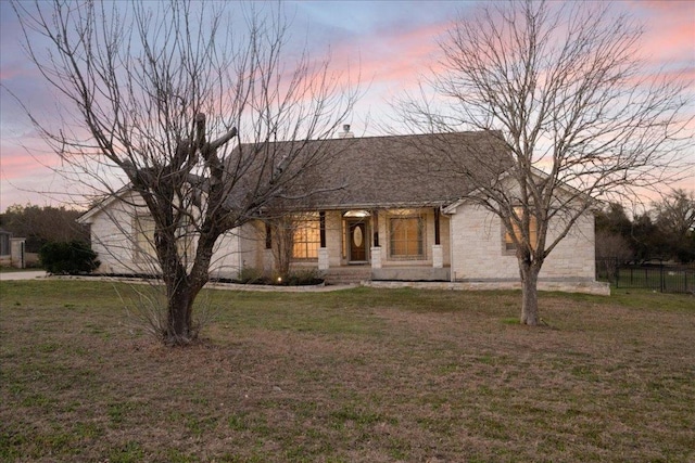 view of front of house with a shingled roof, a front yard, and fence