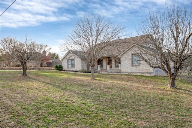 view of front of house featuring stone siding and a front yard