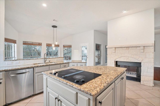 kitchen featuring black electric stovetop, lofted ceiling, visible vents, stainless steel dishwasher, and a sink