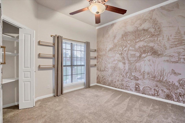 carpeted spare room with ceiling fan, baseboards, and wallpapered walls