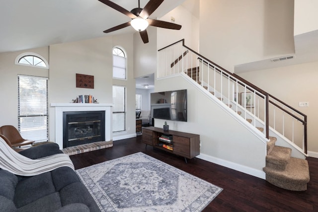 living area featuring stairs, visible vents, baseboards, and wood finished floors