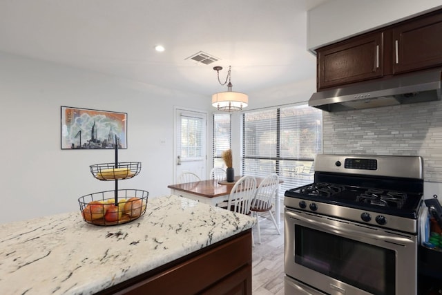 kitchen featuring visible vents, backsplash, dark brown cabinets, gas range, and under cabinet range hood