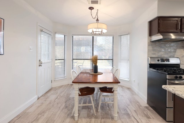 dining space featuring visible vents, light wood-style flooring, and a healthy amount of sunlight