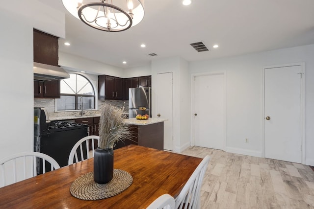 dining room with recessed lighting, visible vents, light wood finished floors, and an inviting chandelier