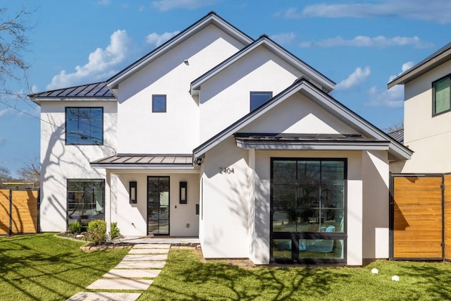 view of front of house with a front yard, a standing seam roof, metal roof, and fence