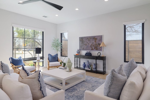 living area with a ceiling fan, visible vents, wood finished floors, and recessed lighting