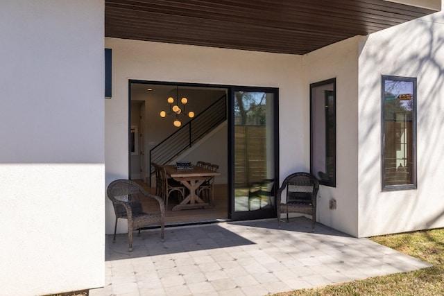 entrance to property with a patio and stucco siding