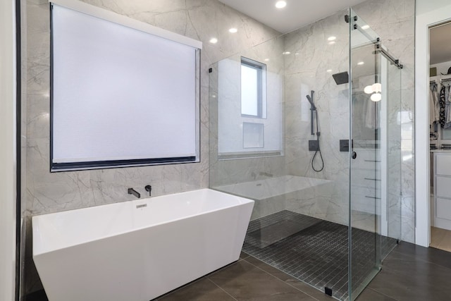 bathroom featuring a stall shower, tile patterned floors, a spacious closet, and a soaking tub