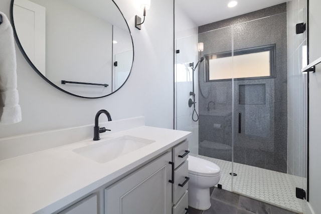 full bathroom featuring a stall shower, vanity, toilet, and tile patterned floors