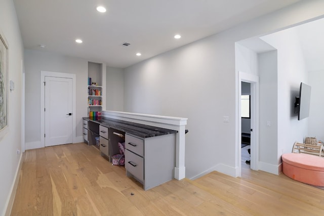 interior space with baseboards, visible vents, an upstairs landing, light wood-type flooring, and recessed lighting