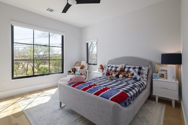 bedroom featuring ceiling fan, wood finished floors, and visible vents