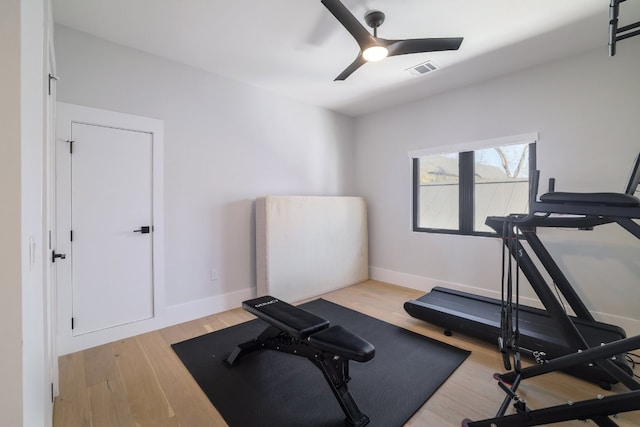 exercise room with ceiling fan, baseboards, visible vents, and light wood-style floors