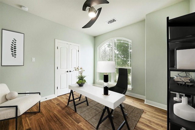 office area featuring baseboards, visible vents, and wood finished floors