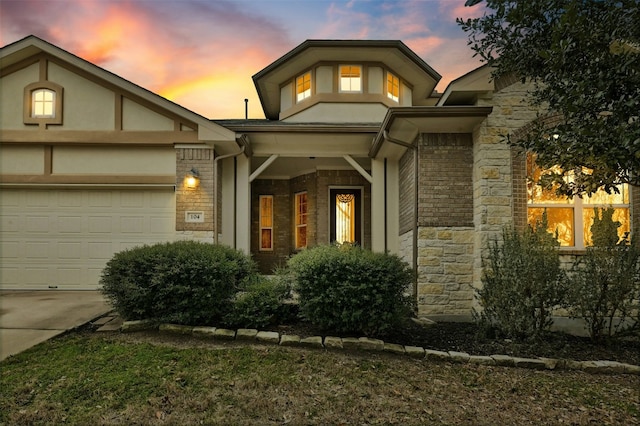 view of front of house with a garage, stone siding, and driveway