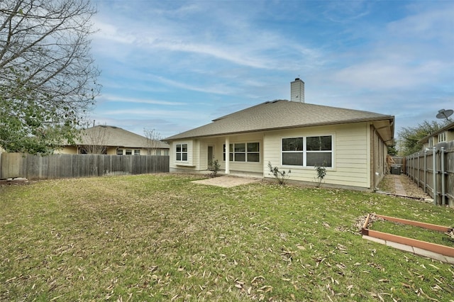 back of house with a yard, a shingled roof, a chimney, and a fenced backyard