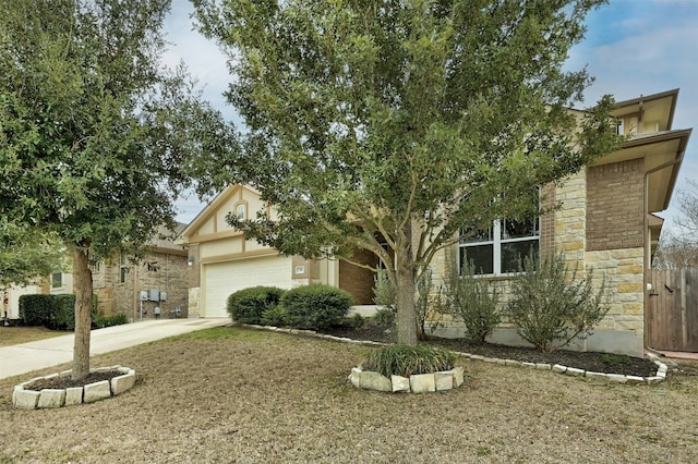 obstructed view of property with an attached garage, stone siding, and concrete driveway